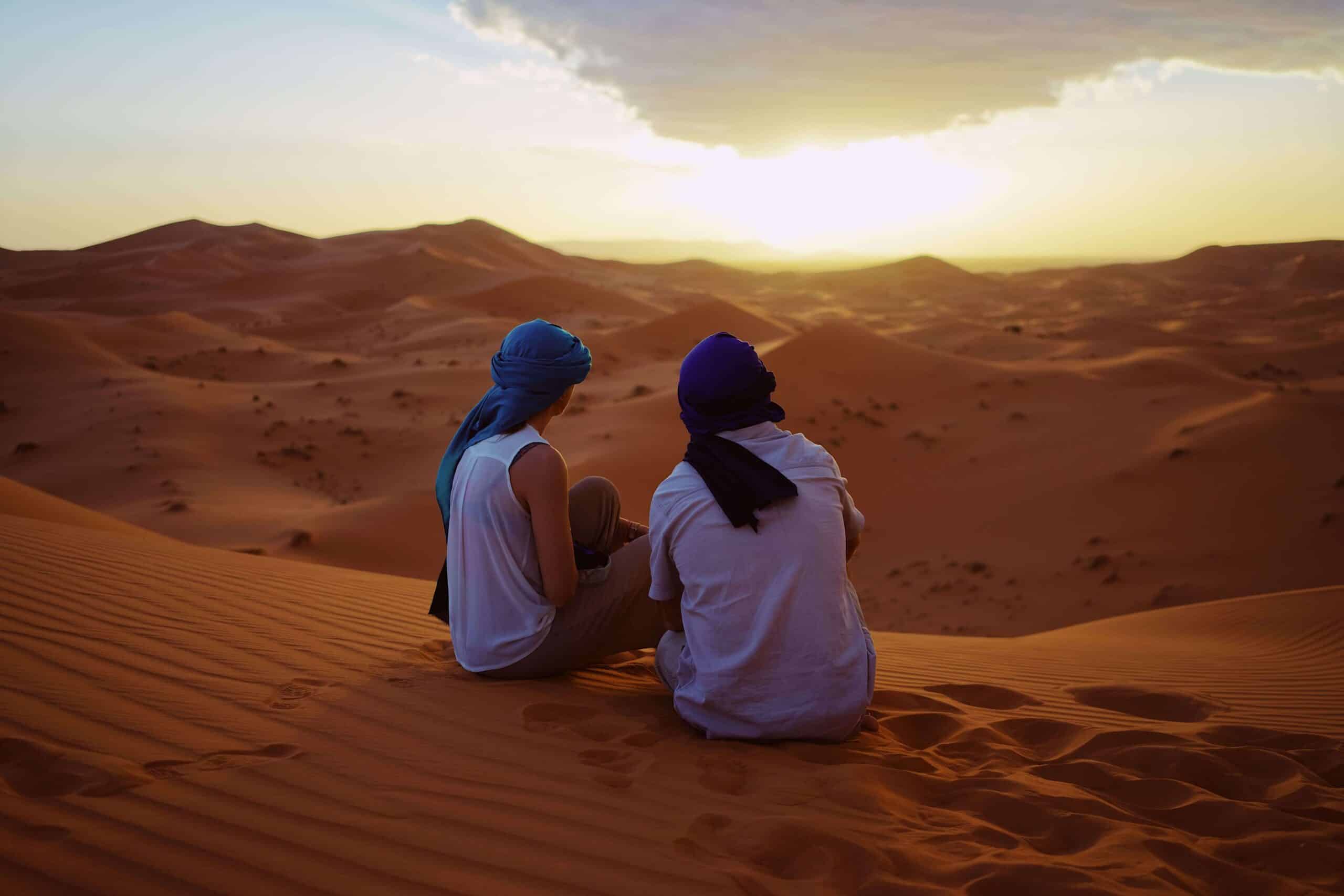 A couple on their honeymoon in Morocco, looking over the Sahara Desert.